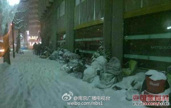 　通宵排队的果粉身上被积雪覆盖。